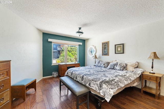 bedroom with a textured ceiling and dark hardwood / wood-style floors