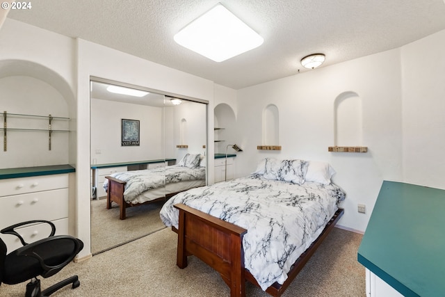 carpeted bedroom featuring a textured ceiling and a closet