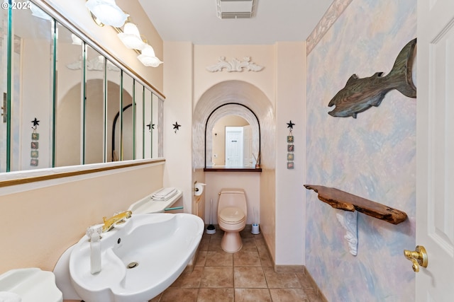 bathroom with sink, a shower with door, tile patterned floors, and toilet