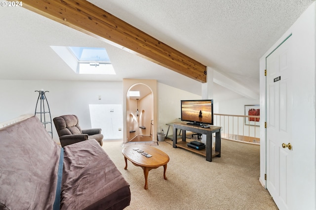 living area with beamed ceiling, a skylight, light colored carpet, and a textured ceiling