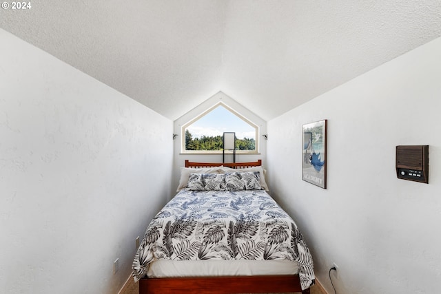 bedroom featuring a textured ceiling and lofted ceiling