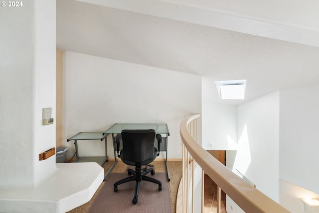 carpeted home office with a textured ceiling