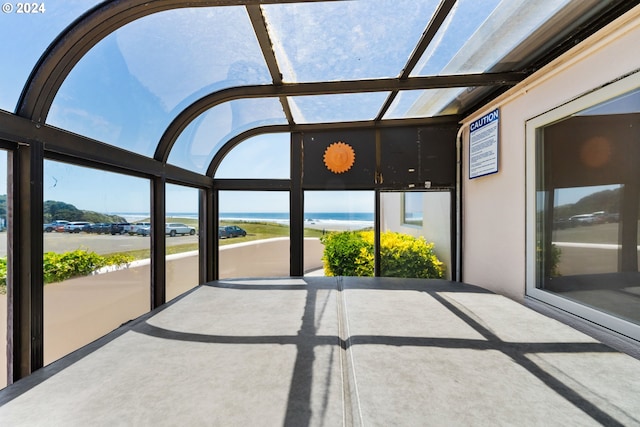 unfurnished sunroom featuring a healthy amount of sunlight and a water view