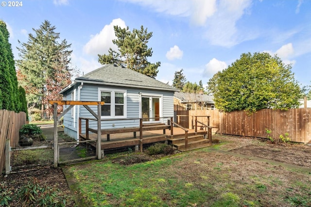 rear view of house featuring a lawn and a deck