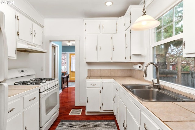 kitchen featuring white cabinetry, sink, white range with gas stovetop, and decorative light fixtures