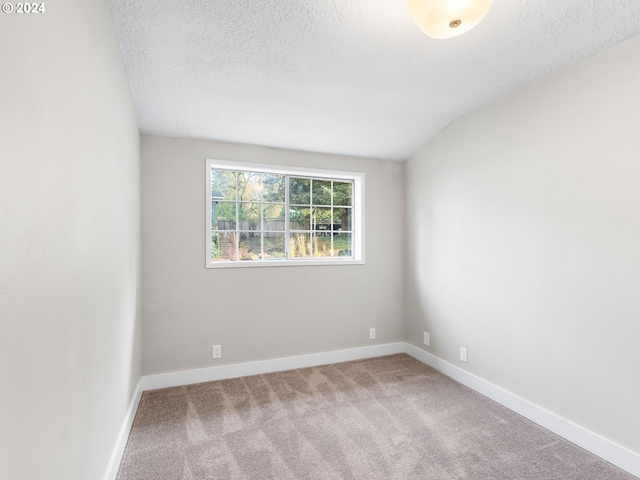 unfurnished room featuring carpet flooring, lofted ceiling, and a textured ceiling