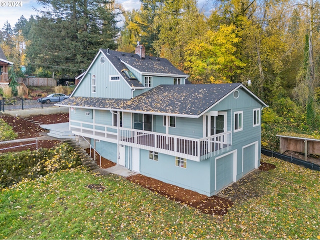 rear view of house featuring a garage and a yard