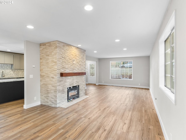 unfurnished living room with a fireplace and light hardwood / wood-style floors