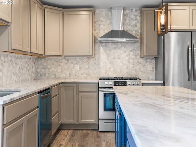 kitchen featuring wall chimney exhaust hood, light wood-type flooring, decorative light fixtures, light stone counters, and stainless steel appliances