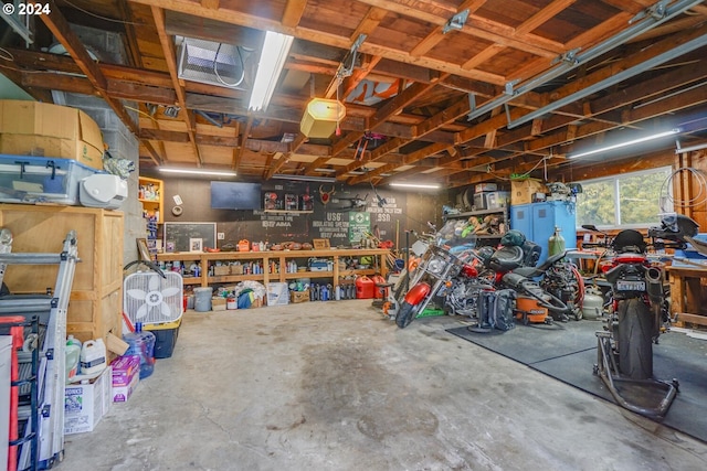 garage with a workshop area and a garage door opener