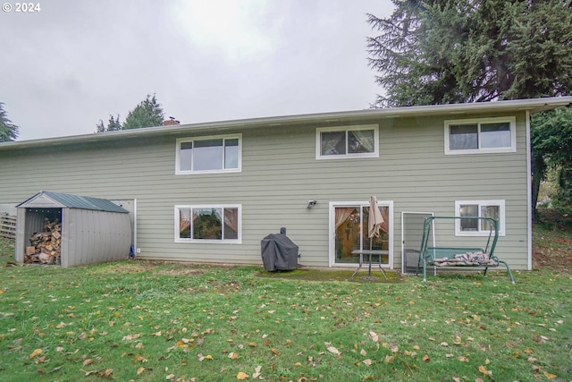 rear view of house with a yard and a shed