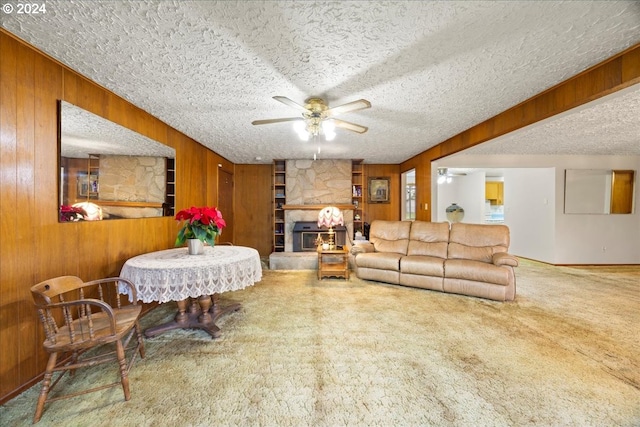 living room with a textured ceiling, carpet floors, and ceiling fan