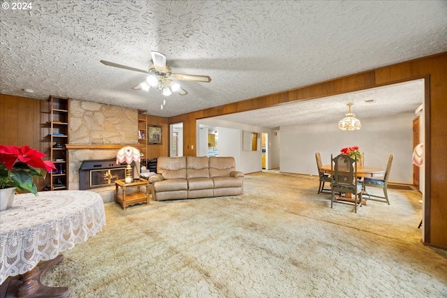 carpeted living room featuring a fireplace, a textured ceiling, ceiling fan, and wooden walls