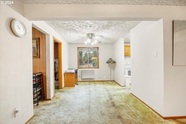 interior space featuring ceiling fan, light colored carpet, and a textured ceiling