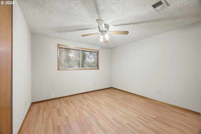 unfurnished room with ceiling fan, a textured ceiling, and light wood-type flooring