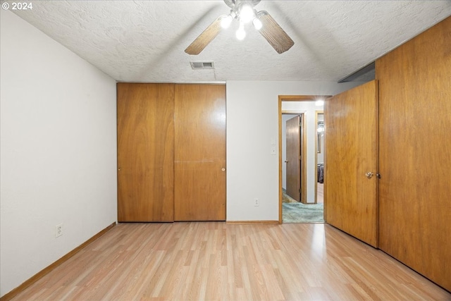 unfurnished bedroom featuring a textured ceiling, light hardwood / wood-style floors, a closet, and ceiling fan