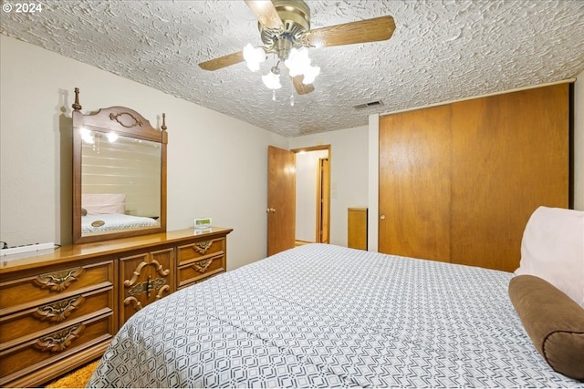 bedroom featuring ceiling fan and a textured ceiling