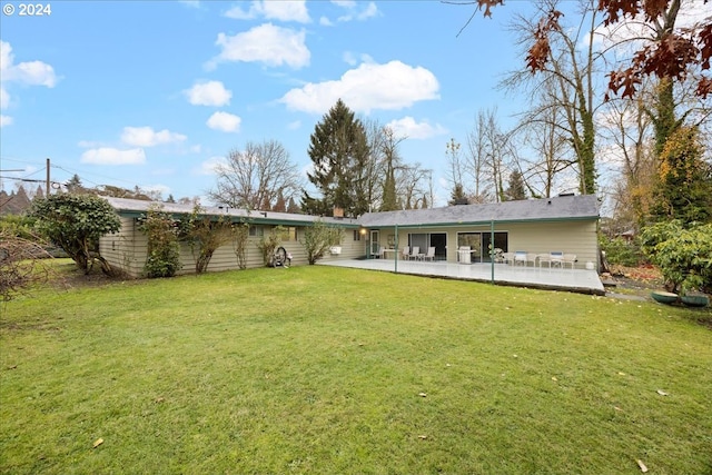 rear view of house featuring a lawn