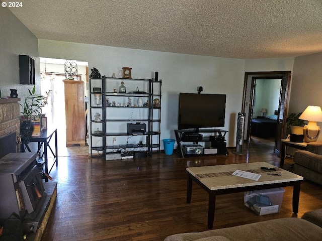 living room with a fireplace, dark hardwood / wood-style flooring, and a textured ceiling