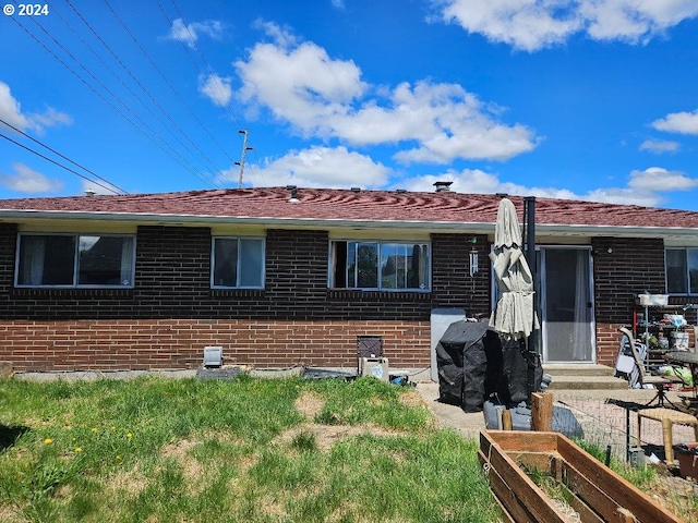 rear view of property featuring a lawn