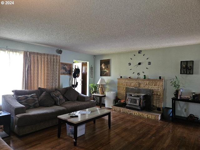 living room with wood-type flooring, a textured ceiling, and a wood stove