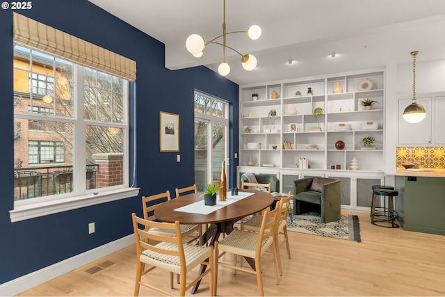 dining space featuring light hardwood / wood-style floors and a chandelier