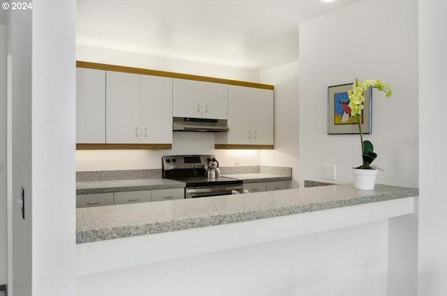 kitchen featuring stainless steel electric stove and white cabinetry