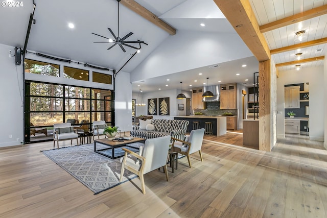 living room with ceiling fan, beamed ceiling, high vaulted ceiling, and light wood-type flooring