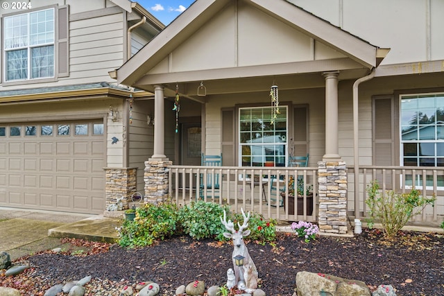 view of front of house featuring stone siding, a porch, and an attached garage