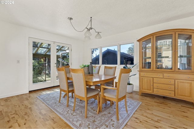 dining area featuring a textured ceiling, a healthy amount of sunlight, and light wood-type flooring