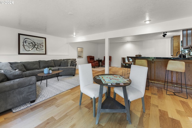 dining space featuring sink, a textured ceiling, and light hardwood / wood-style floors