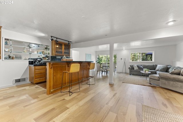 bar featuring light hardwood / wood-style floors and a textured ceiling