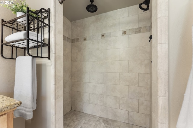 bathroom with vanity and tiled shower