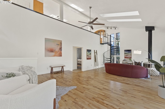 living room featuring high vaulted ceiling, light wood-type flooring, and ceiling fan