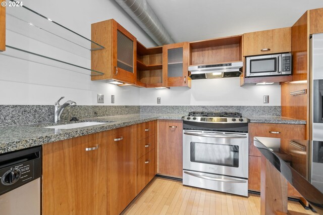 kitchen featuring sink, stainless steel appliances, stone countertops, and light hardwood / wood-style flooring