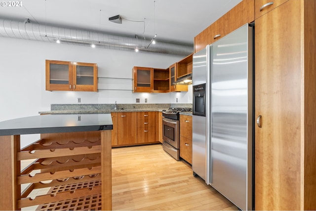 kitchen with light hardwood / wood-style floors, a breakfast bar area, stainless steel appliances, and a kitchen island