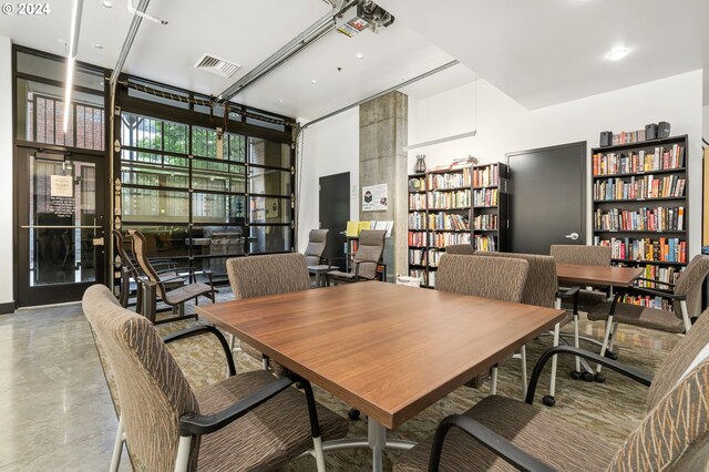 dining room with expansive windows and concrete flooring