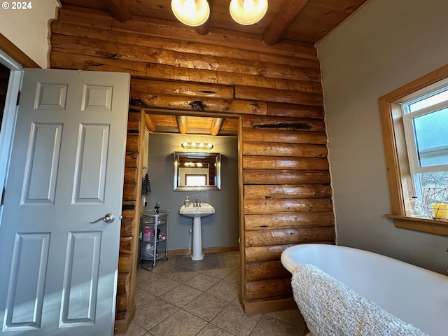 bathroom with wooden ceiling, tile patterned flooring, a freestanding tub, beam ceiling, and rustic walls