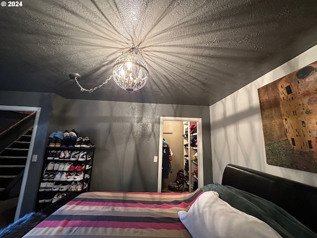 bedroom with a closet, a walk in closet, and a textured ceiling