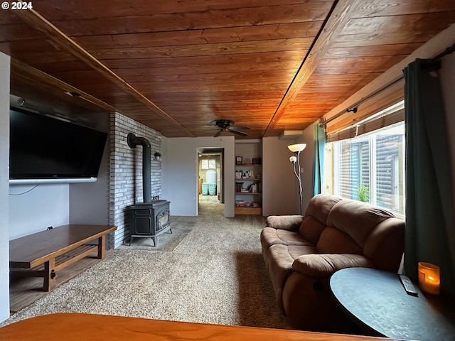 living room with a wood stove, wood ceiling, ceiling fan, and carpet flooring