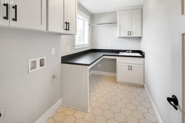 laundry room featuring sink, washer hookup, cabinets, and light tile floors