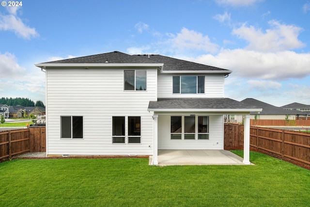 rear view of house with a patio and a lawn