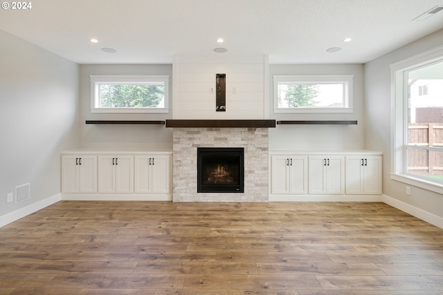 unfurnished living room featuring plenty of natural light and wood-type flooring