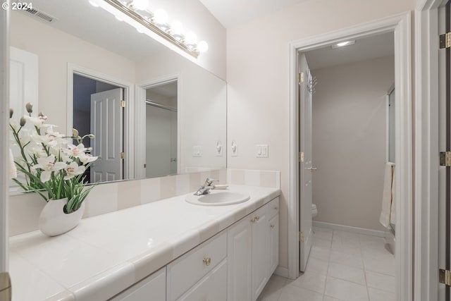 bathroom with tile patterned flooring, vanity, and toilet