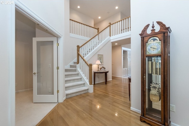 entrance foyer with a towering ceiling and light wood-type flooring