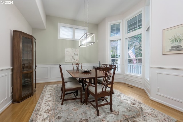 dining area featuring light wood-type flooring and an inviting chandelier