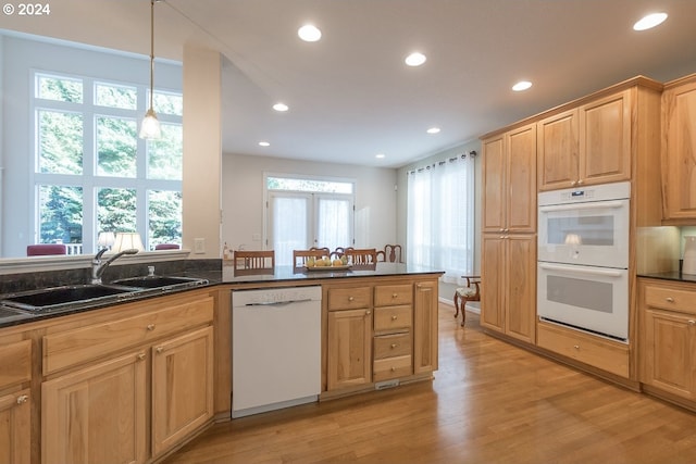 kitchen featuring light wood-type flooring, white appliances, sink, pendant lighting, and plenty of natural light