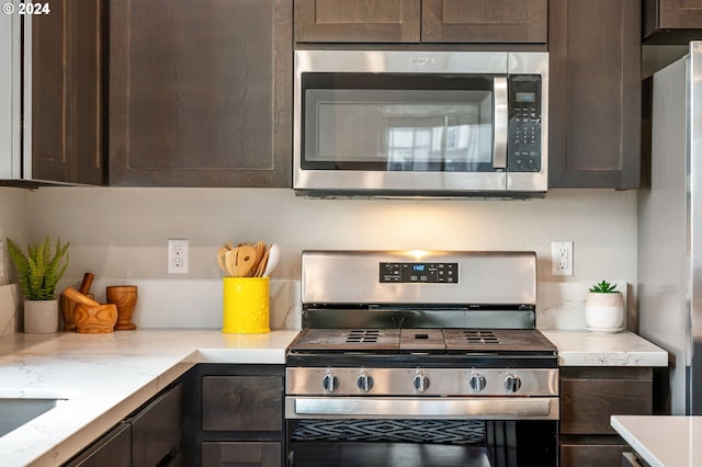 kitchen featuring dark brown cabinetry and appliances with stainless steel finishes