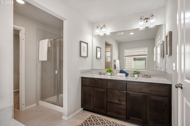 bathroom with walk in shower, vanity, and tile patterned flooring