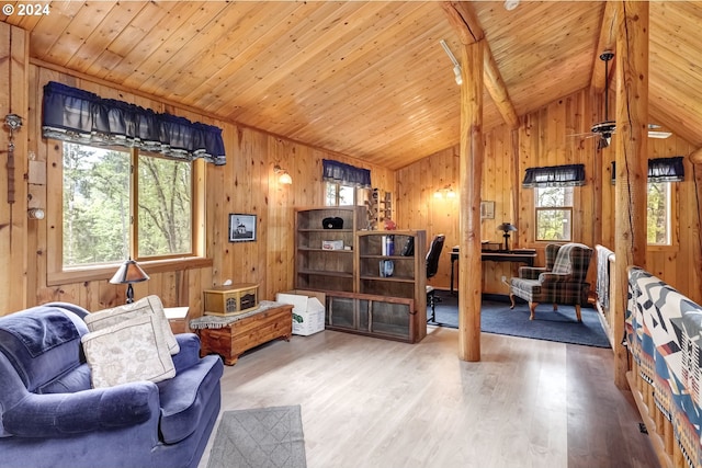 sitting room with wooden walls, plenty of natural light, wood-type flooring, and vaulted ceiling with beams